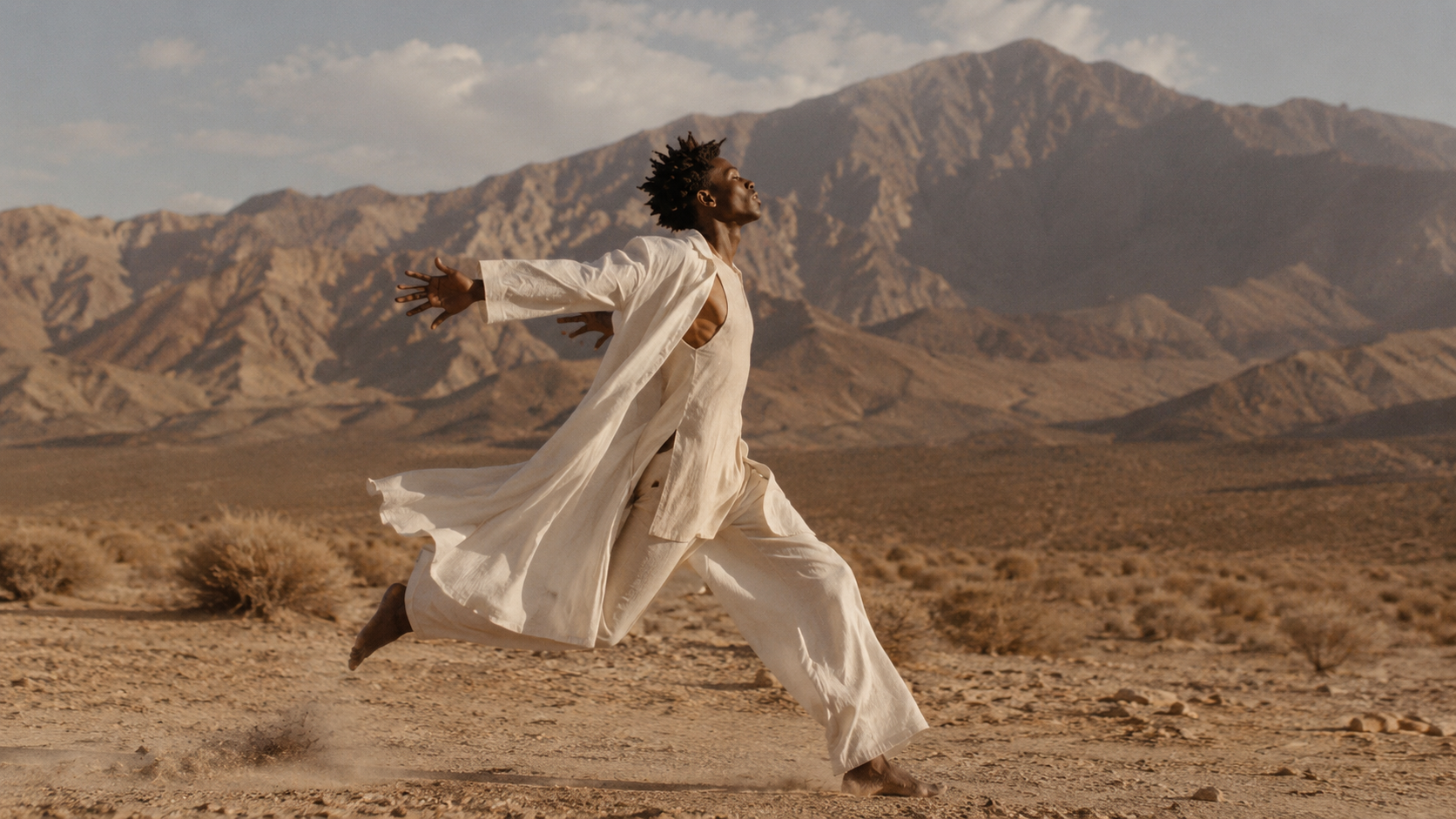 A figure running across open desert ground